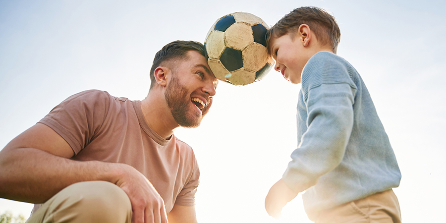 pai e filho jogando bola e se divertindo 